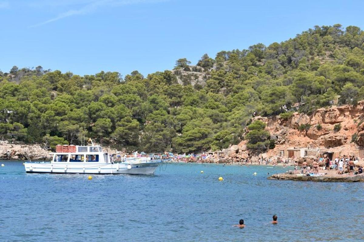 a boat in the water next to a group of people