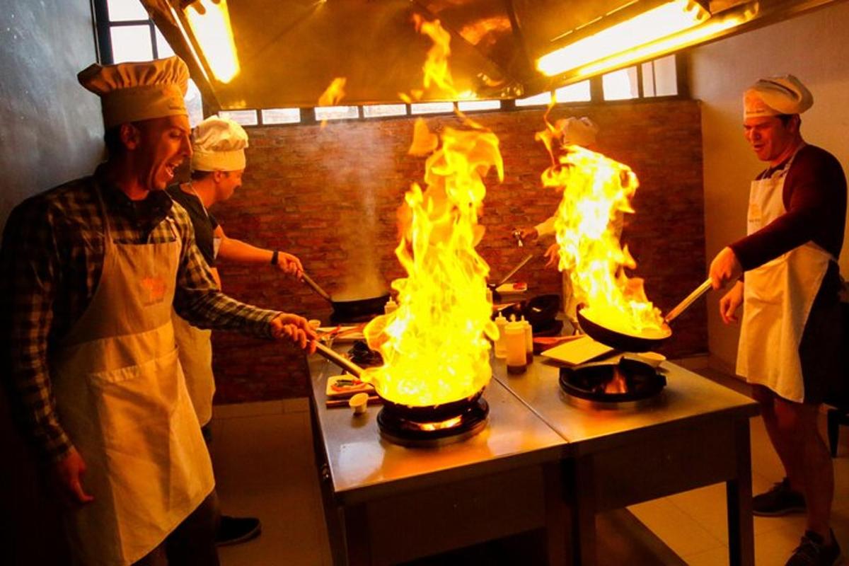 sekumpulan chef memasak di dapur dengan api