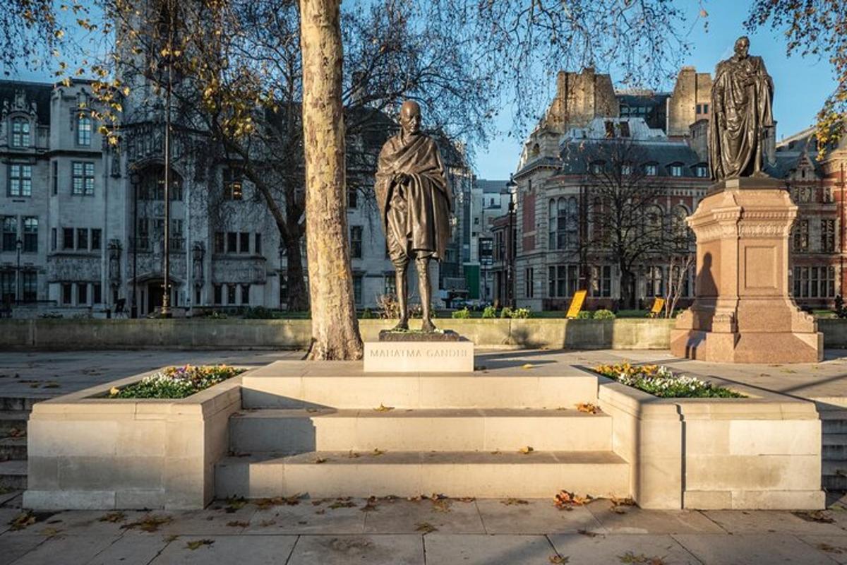 a statue of a man standing next to a tree