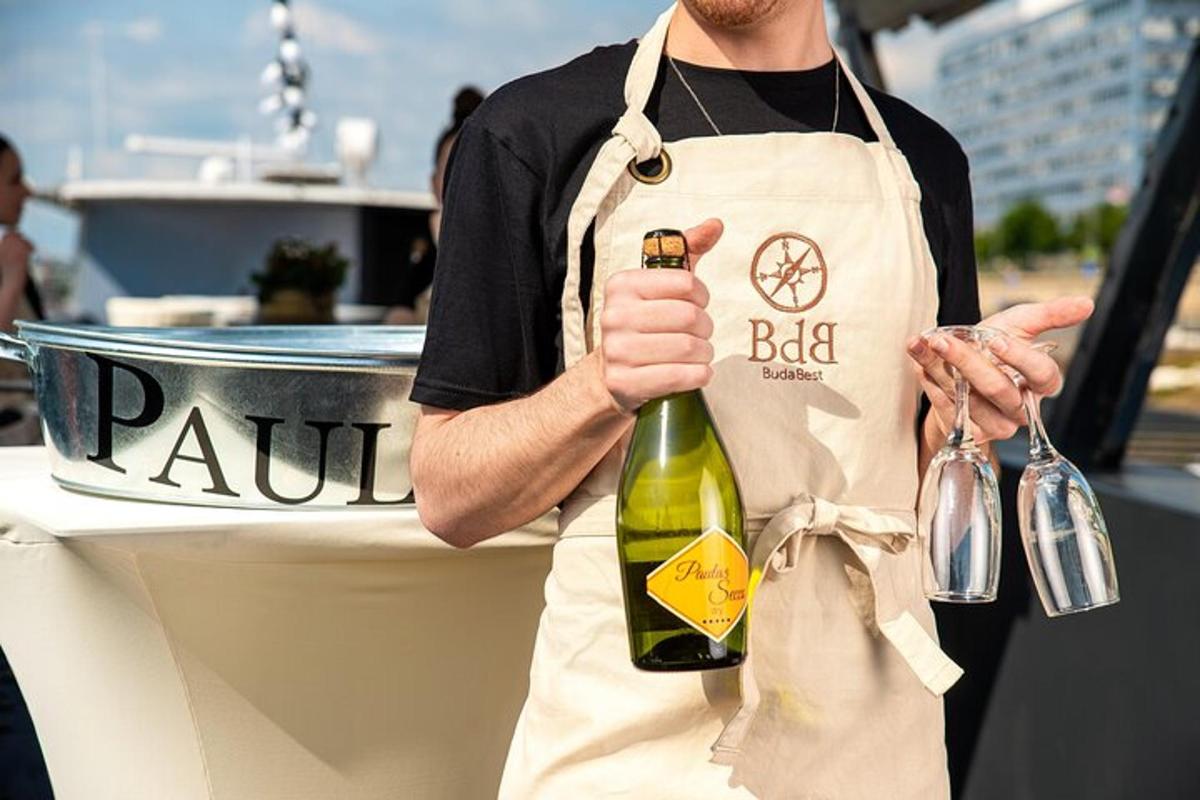 un uomo con un grembiule che tiene in mano una bottiglia di vino