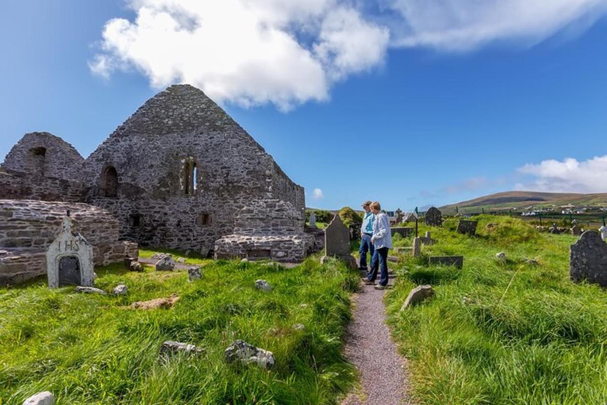 two people walking down a path in front of an old building