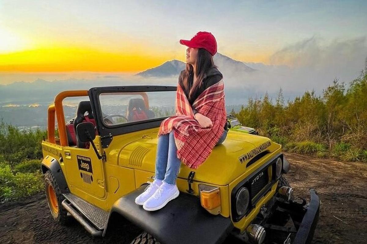 isang babaeng nakaupo sa hood ng isang trak