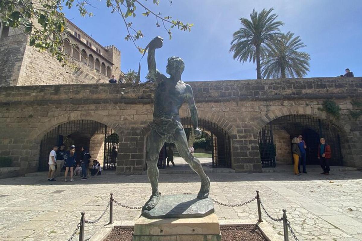 una statua di un uomo che tiene una bandiera davanti a un edificio