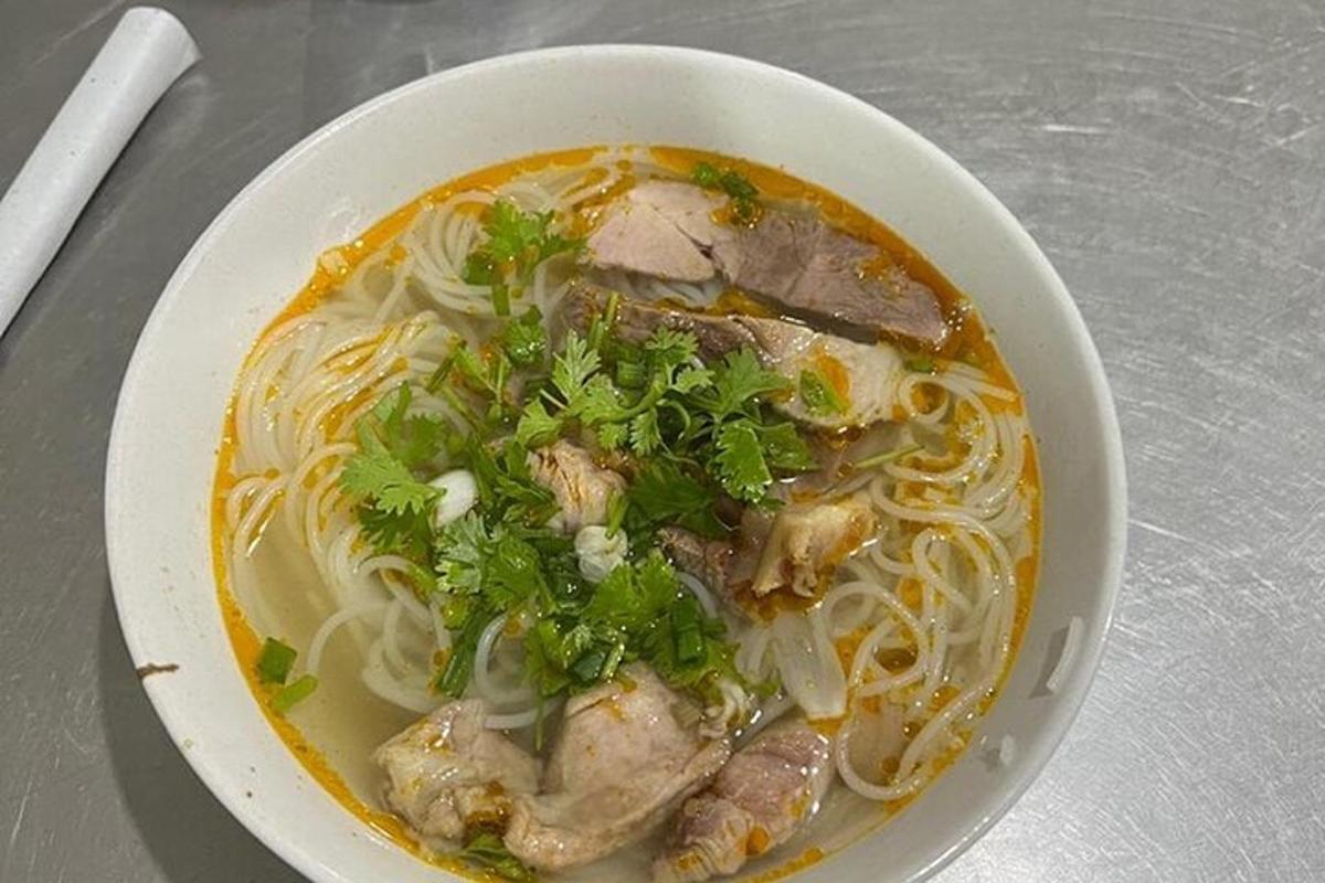 uma tigela de sopa de macarrão com carne e vegetais