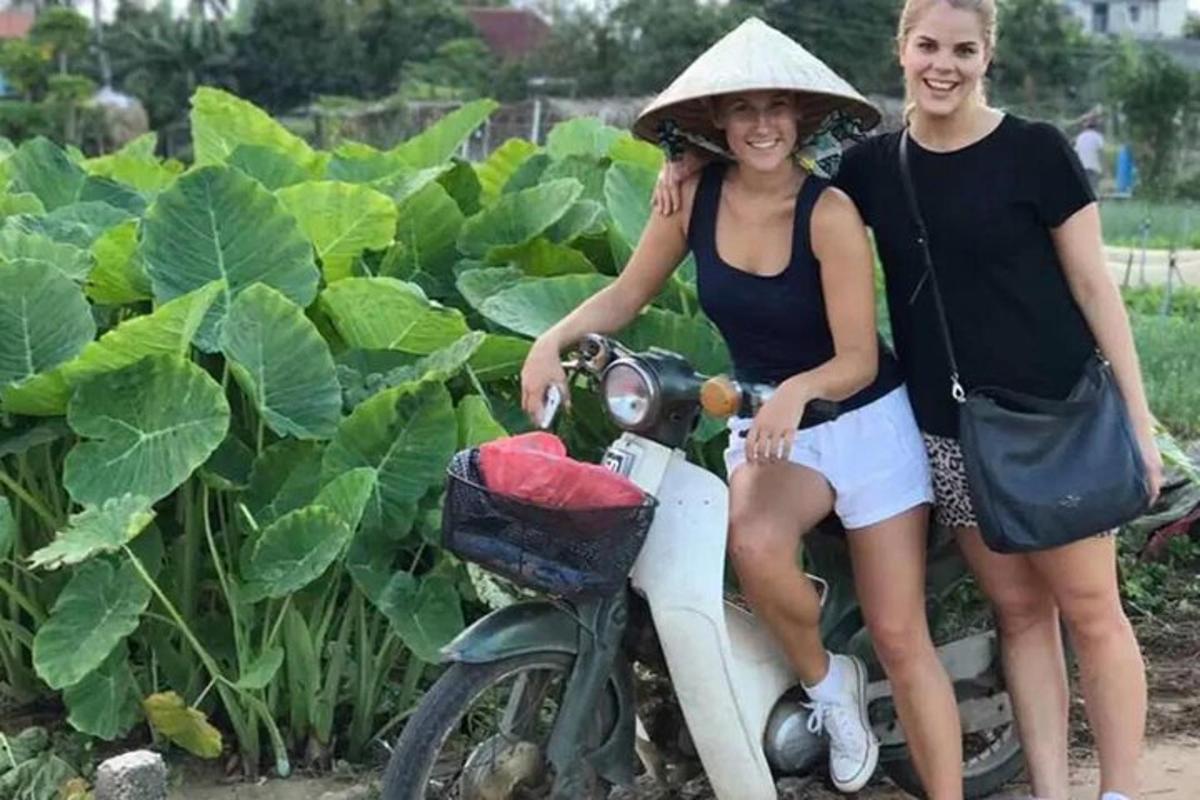 一名女子坐在摩托车上，旁边还有另一名女子