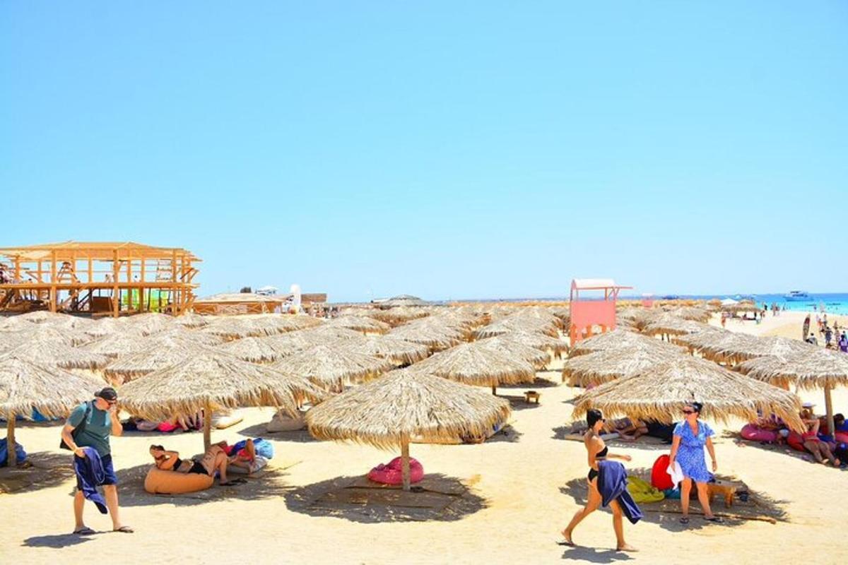 un gruppo di persone su una spiaggia con ombrelloni di paglia