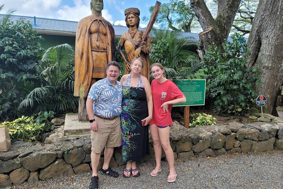 três mulheres estão em pé em frente a uma estátua