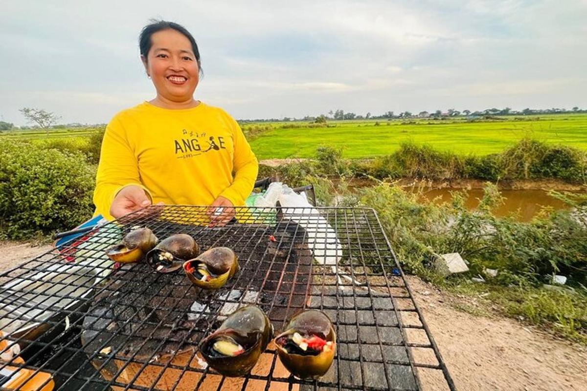 Una mujer parada junto a una parrilla con pájaros en ella.