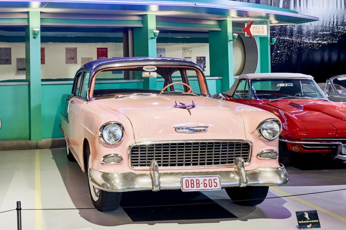 two old cars are parked in a garage