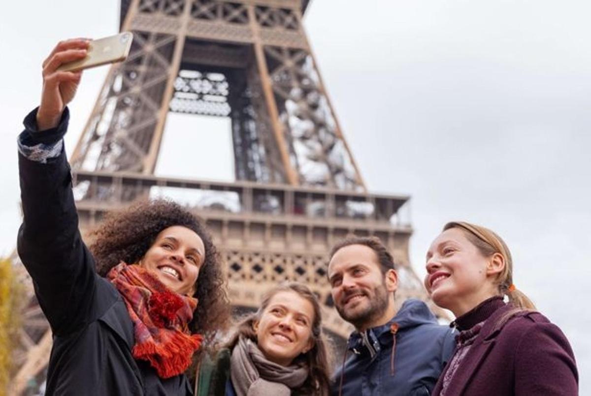 một nhóm người đang đứng trước tháp Eiffel