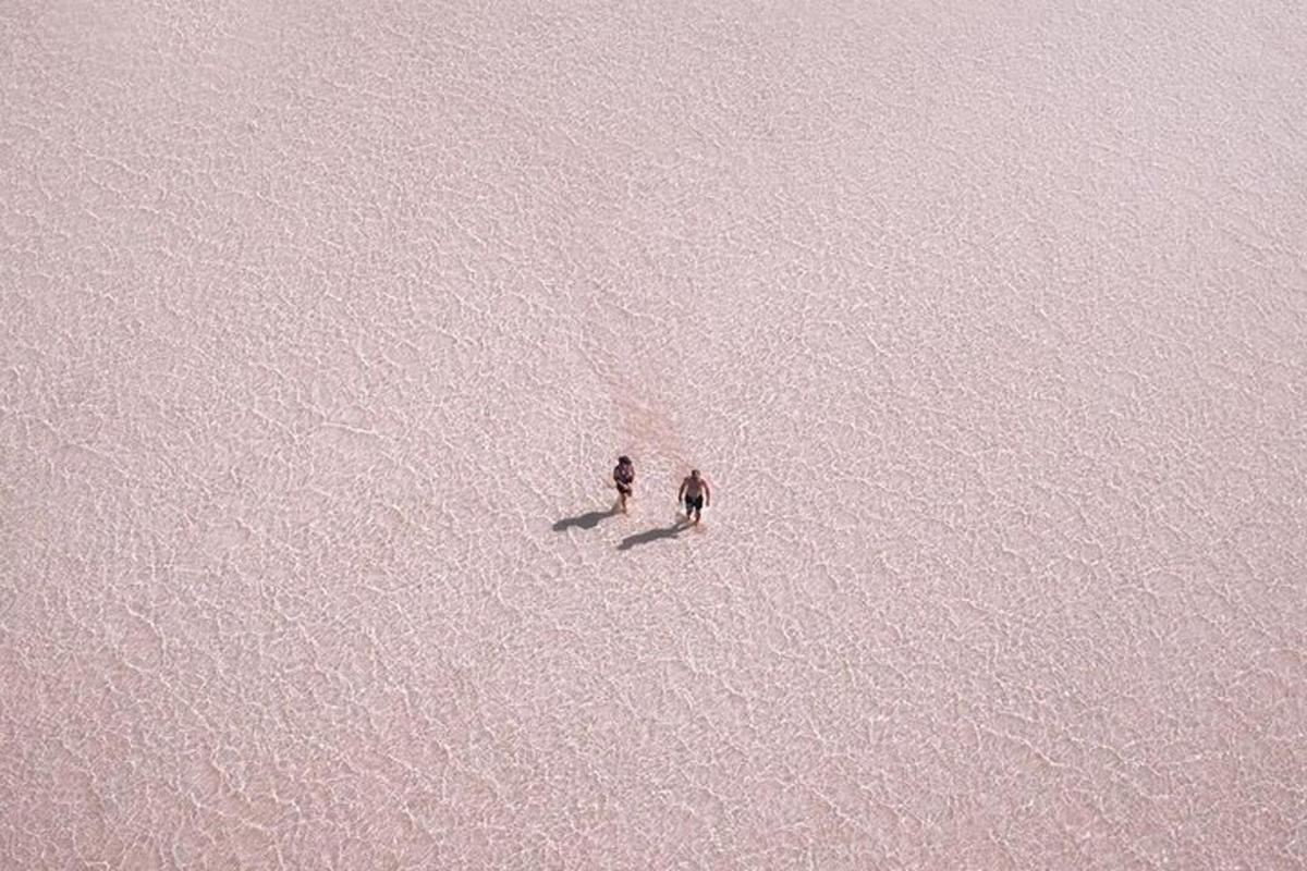 two people standing in the middle of a body of water
