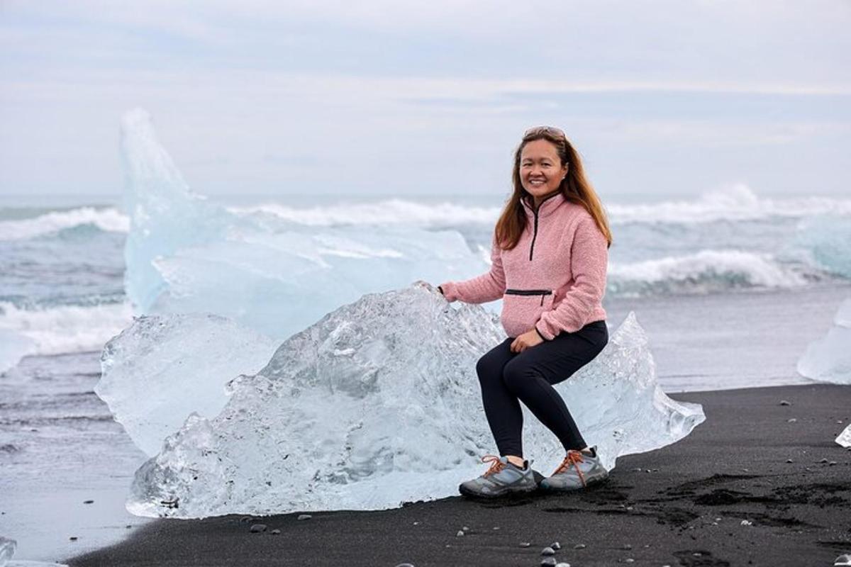 kona situr á ísblett á ströndinni