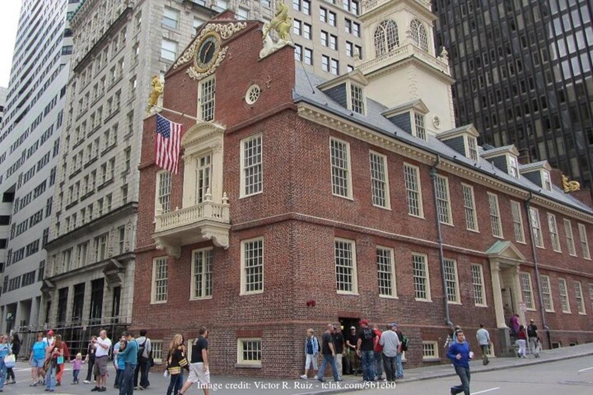 a group of people walking in front of a brick building