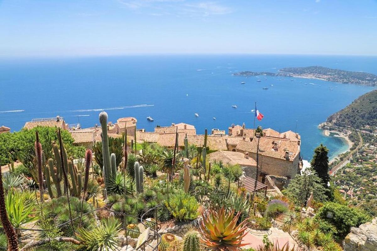 Un castillo en la cima de una colina con cactus y el océano.