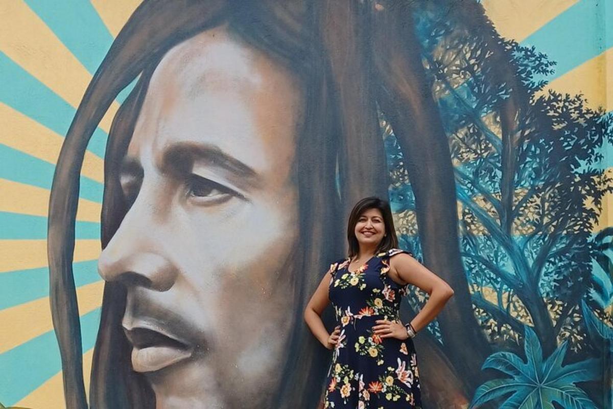uma mulher está parada em frente a um mural