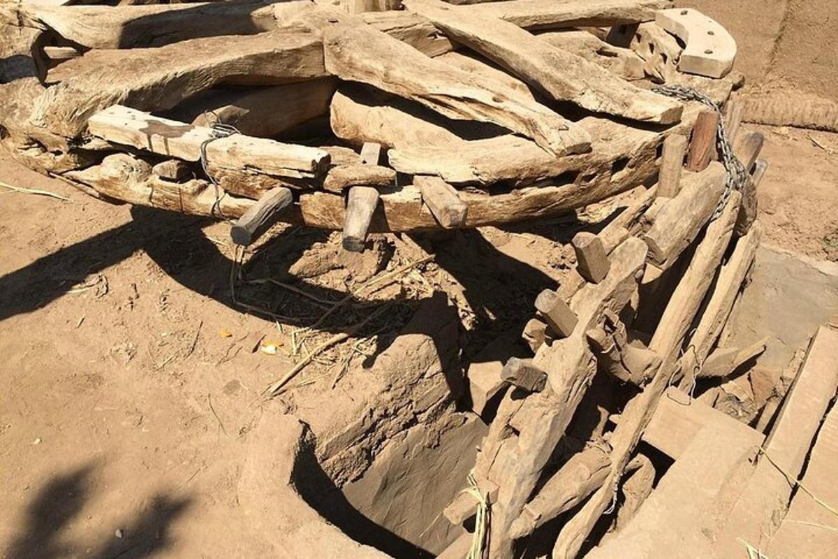 a pile of logs and rocks on a dirt field