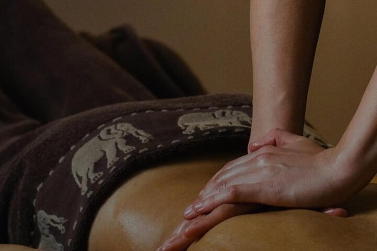 eine Frau, die mit der Hand auf einem Kissen auf einem Bett sitzt