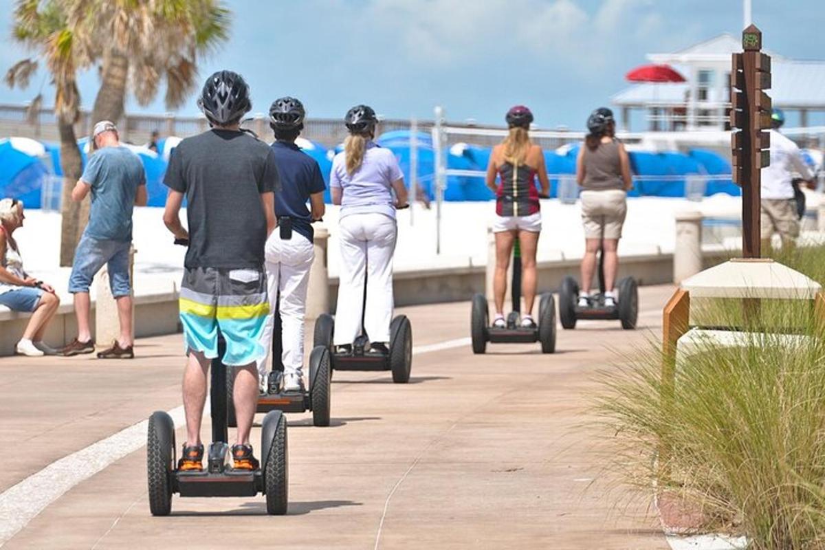 a group of people riding on segways near the beach