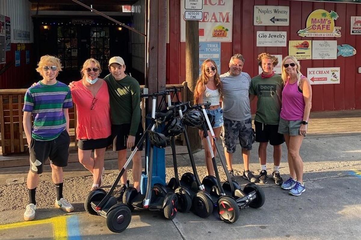 a group of people standing next to a group of scooters