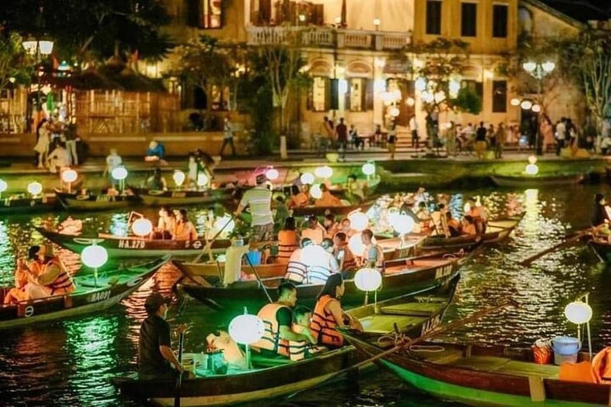 un gruppo di persone in barca su un fiume di notte