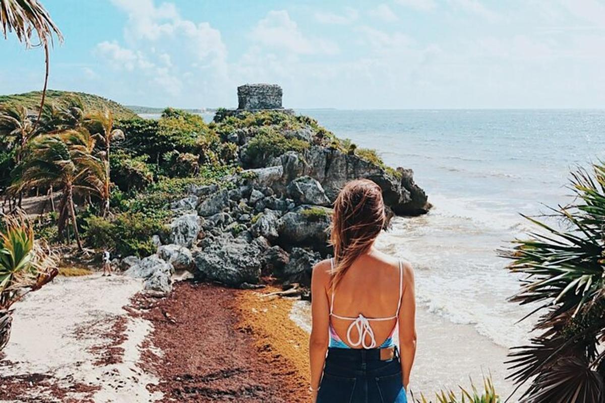 ženska, ki stoji na plaži in gleda na ocean