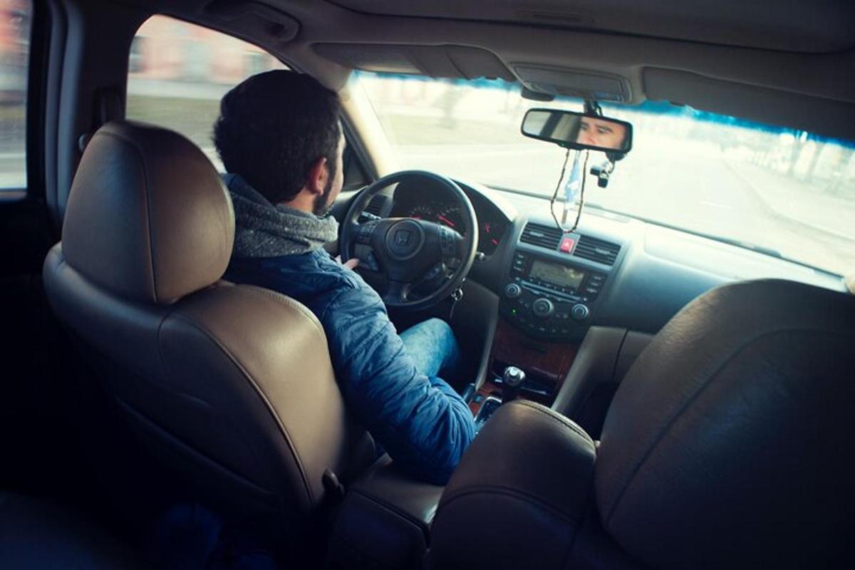 un uomo seduto al volante di un'auto