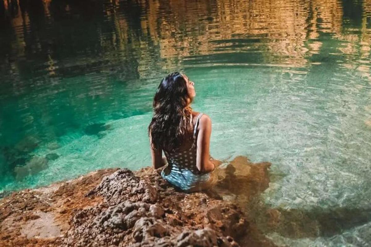 una donna seduta su una roccia nell'acqua