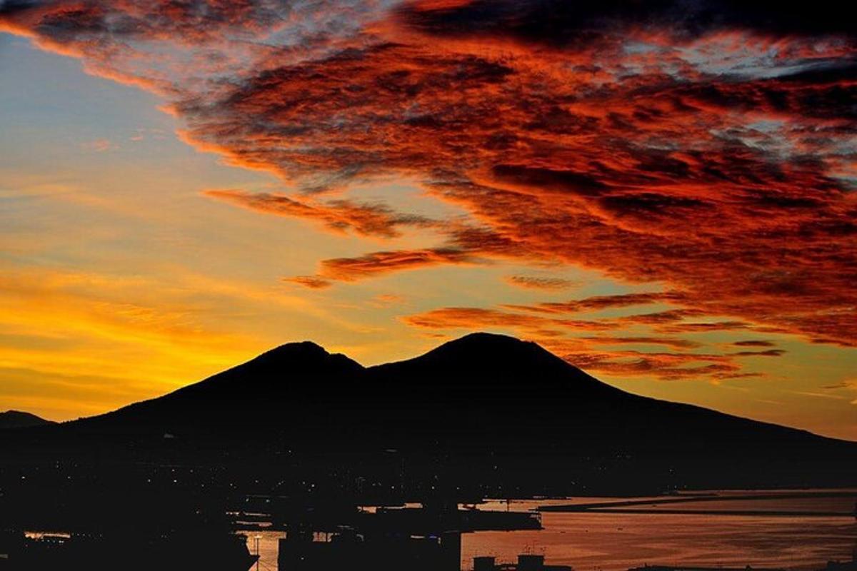 Una puesta de sol con una montaña frente al agua
