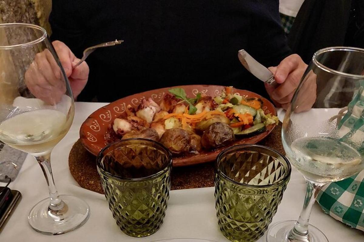 a plate of food on a table with glasses of wine