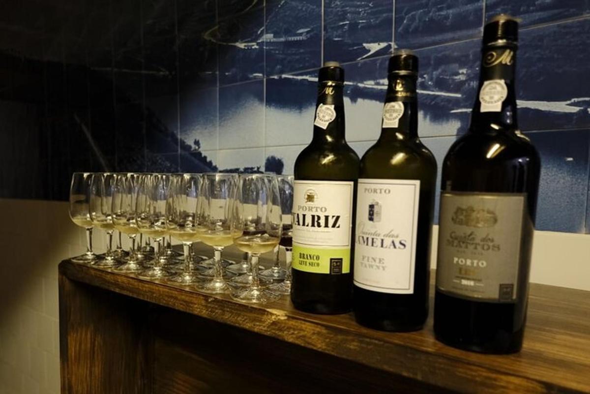 three bottles of wine sitting on a counter with glasses