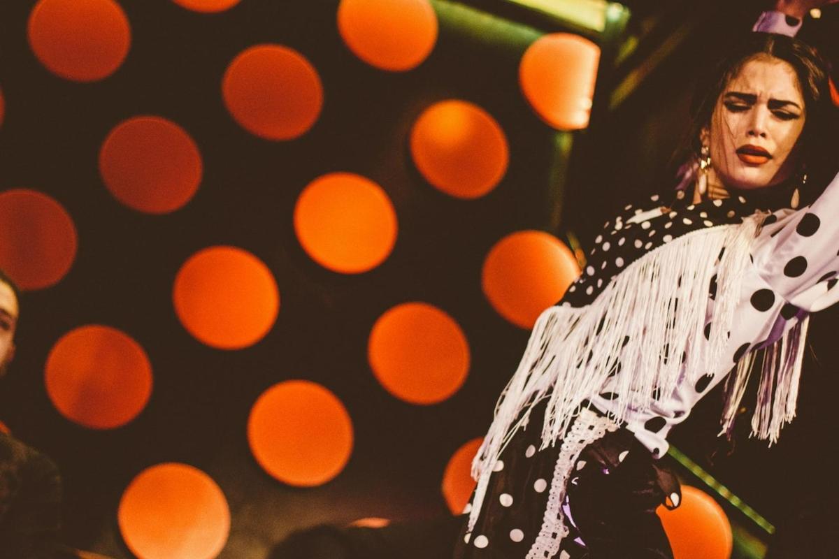 Žena vystupuje na pódiu s oranžovými kruhy