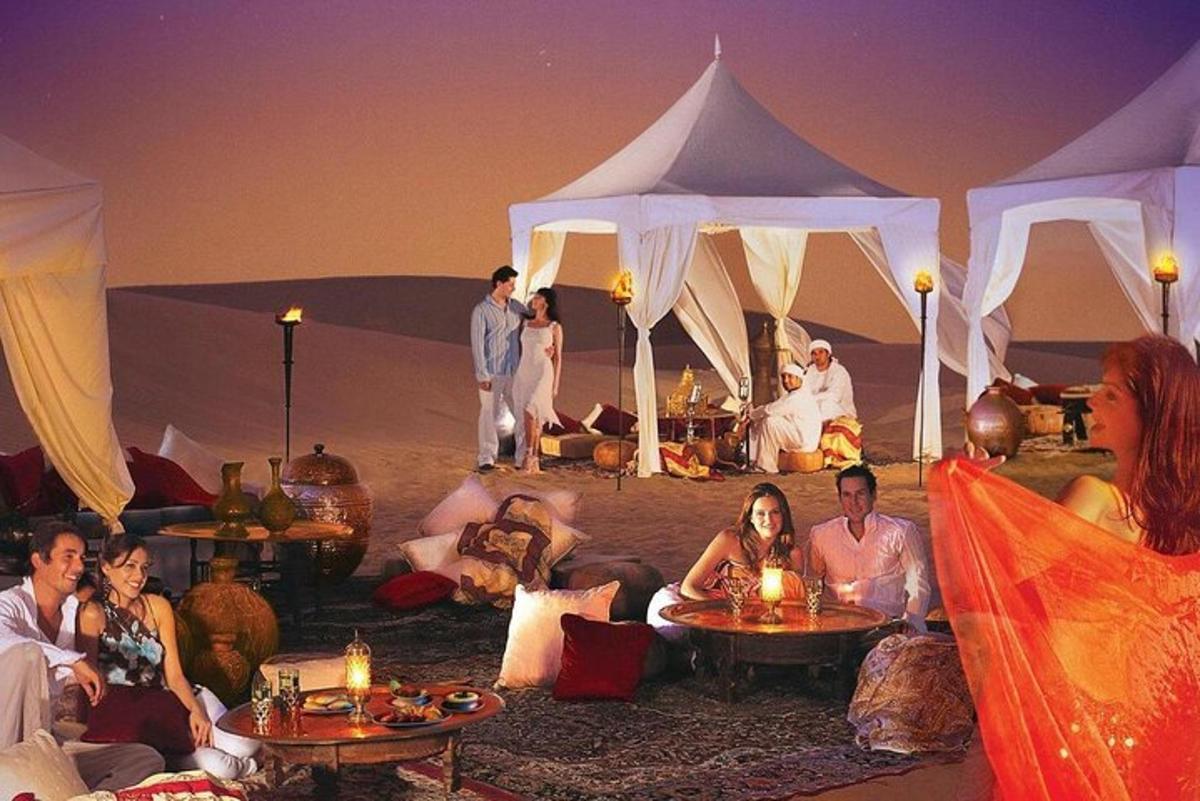 a group of people sitting in front of tents in the desert