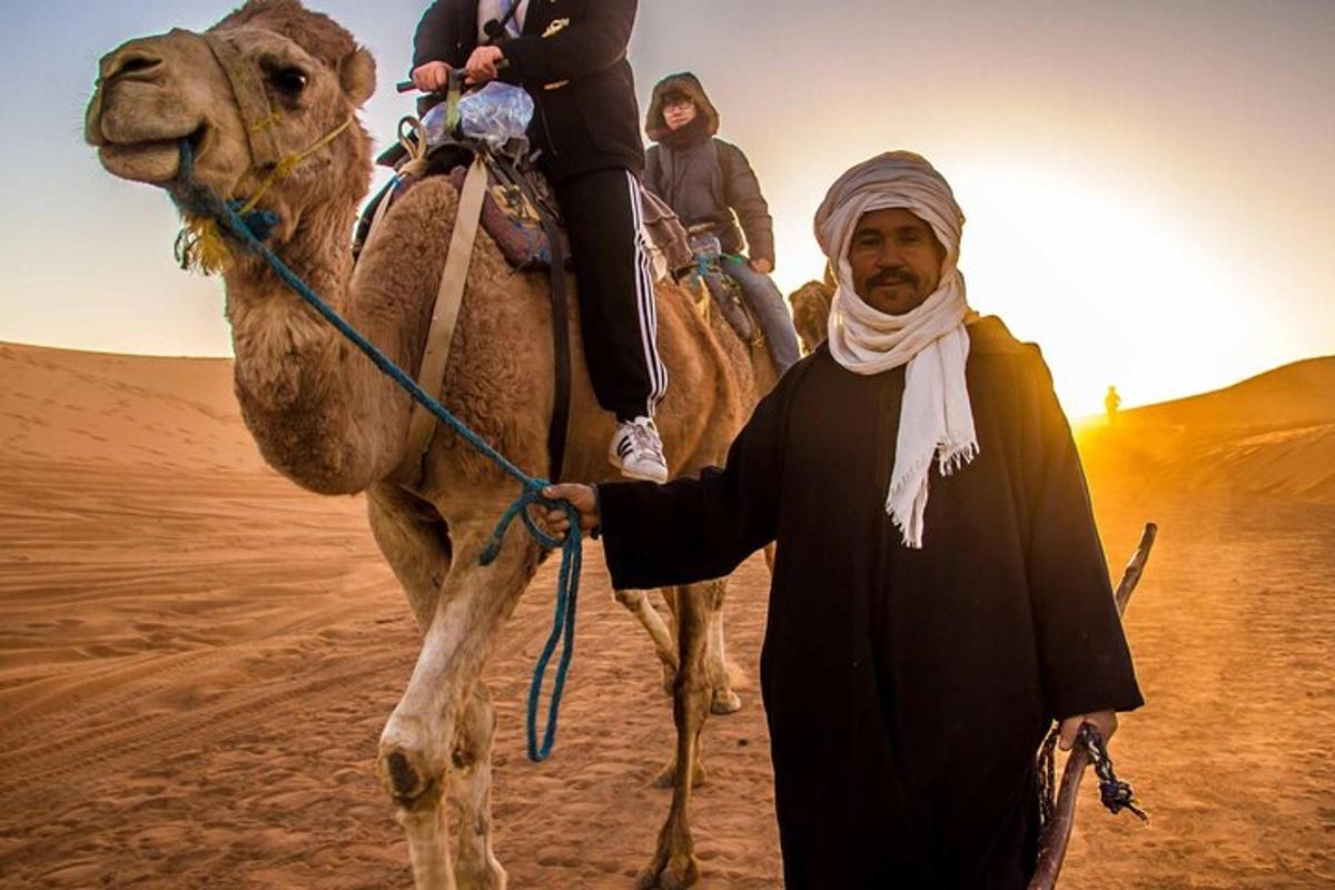 um homem conduzindo um camelo no deserto