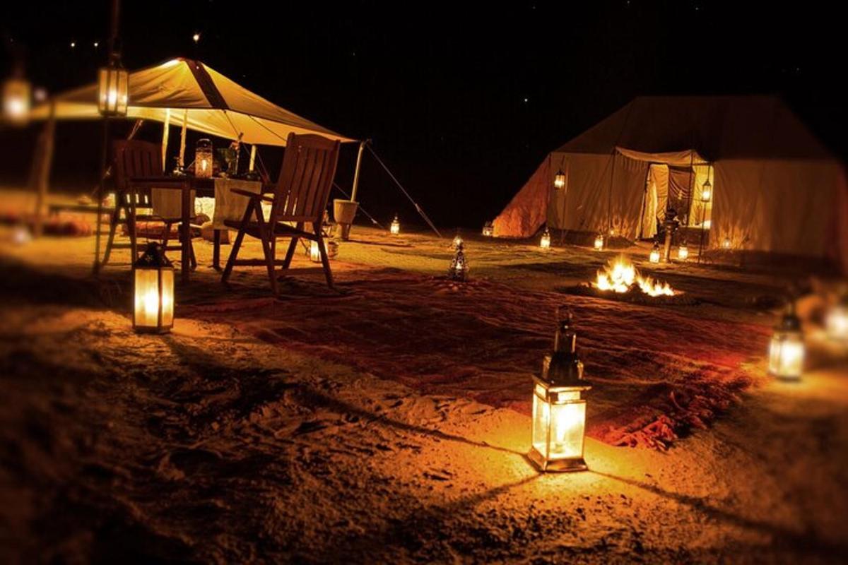 uma barraca com luzes na areia à noite