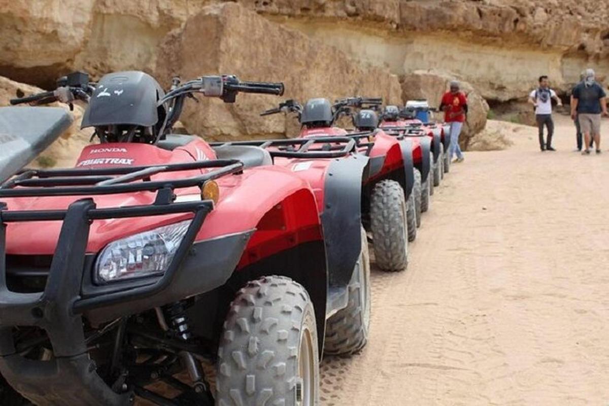 un rând de ATV-uri parcate pe un drum de pământ