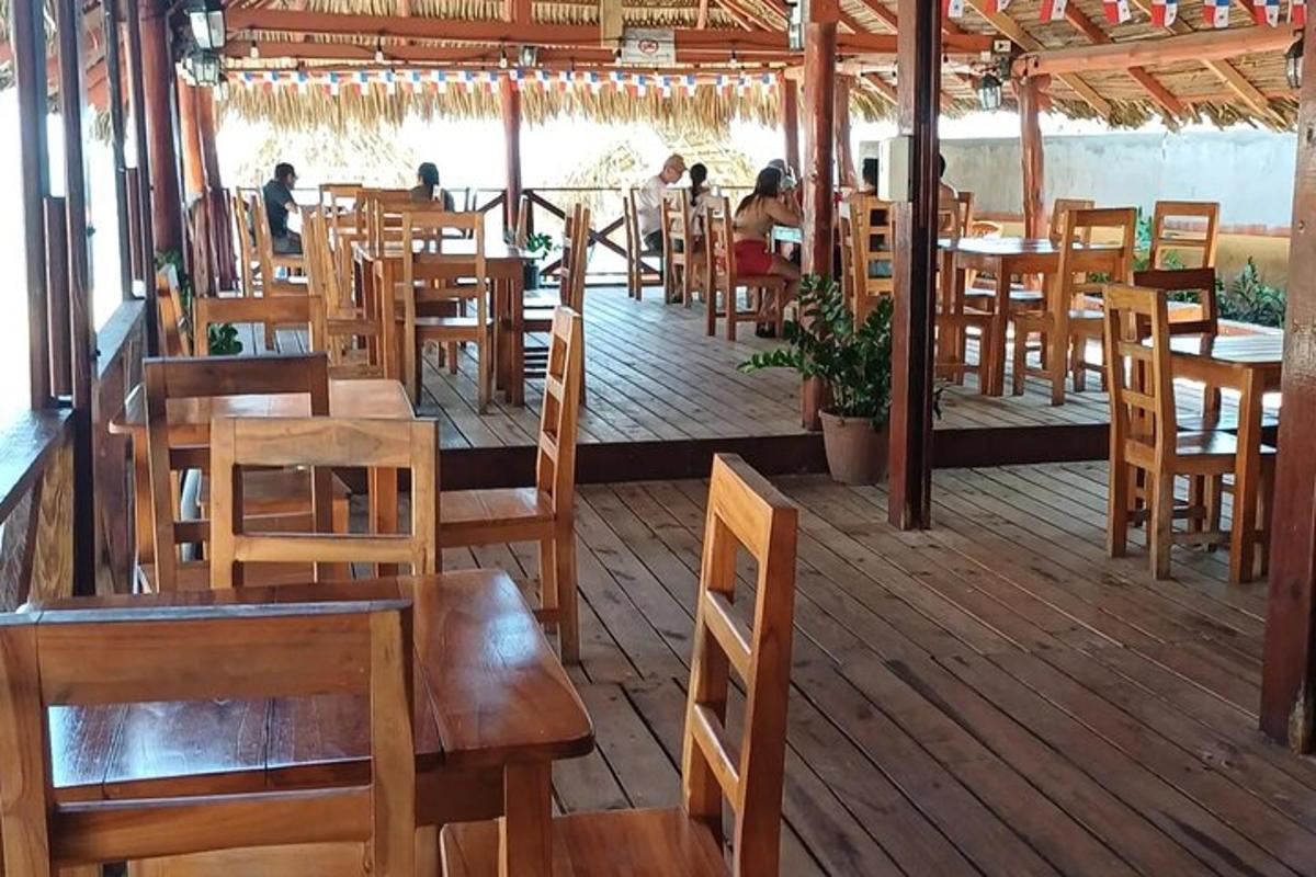 một nhà hàng có bàn ghế gỗ trên boong tàu