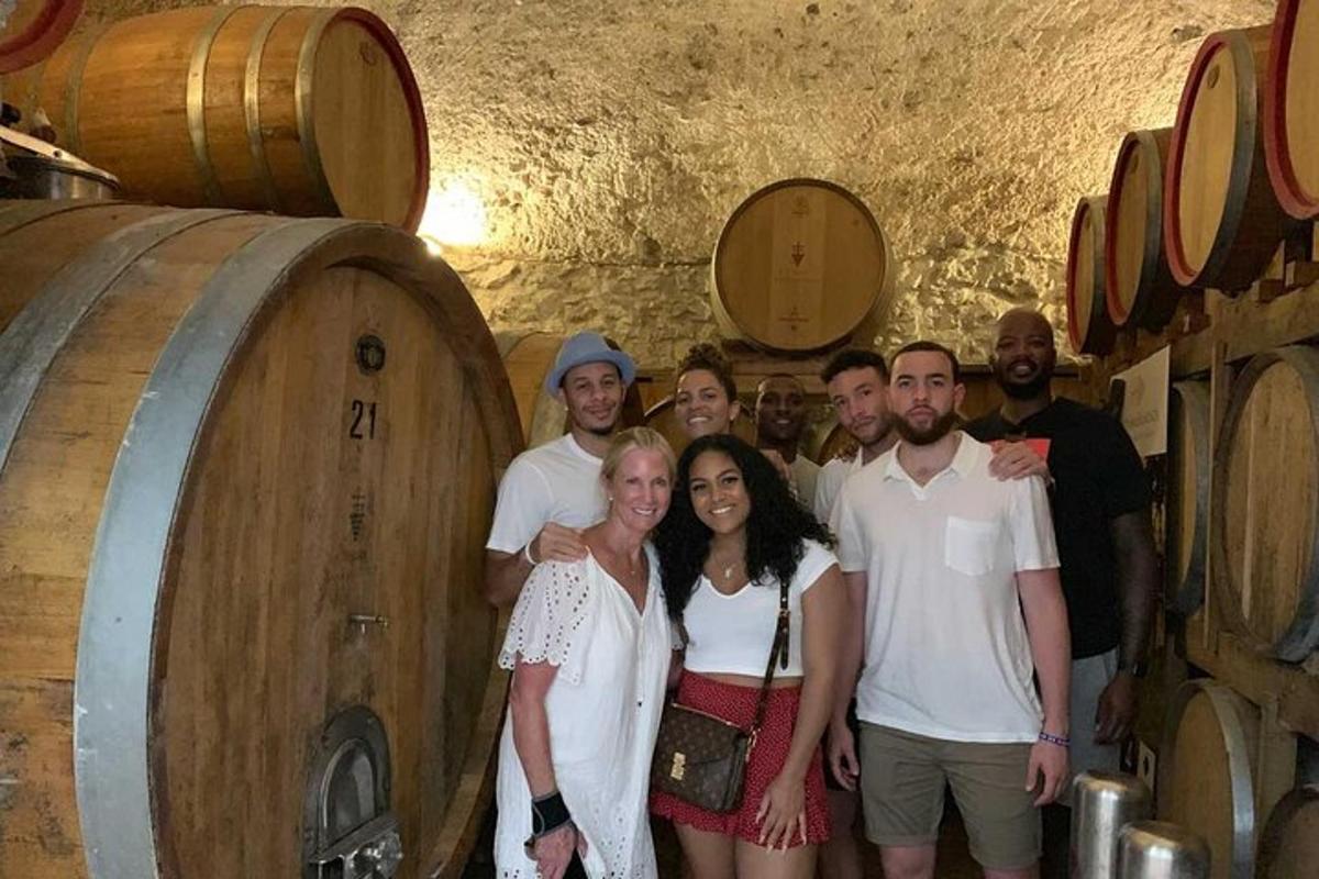 a group of people standing in a wine cellar