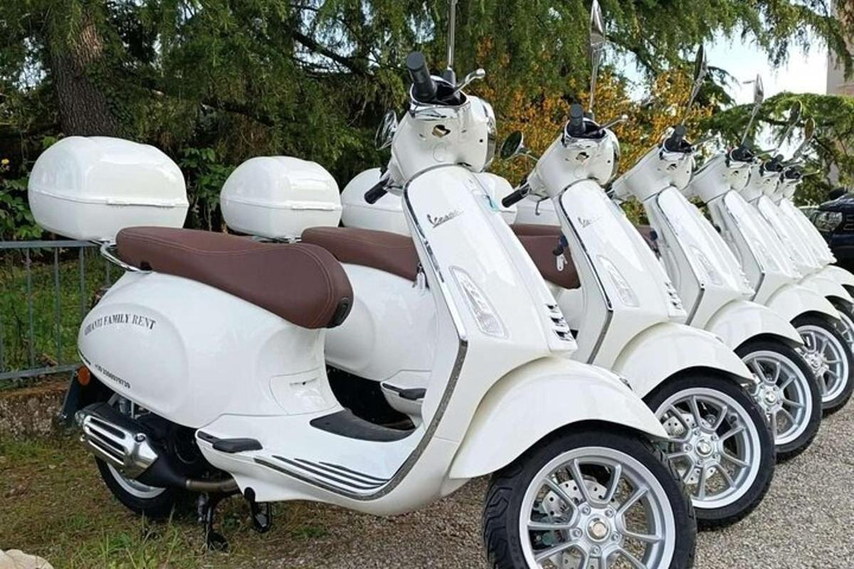 una fila di scooter bianchi parcheggiati uno accanto all'altro