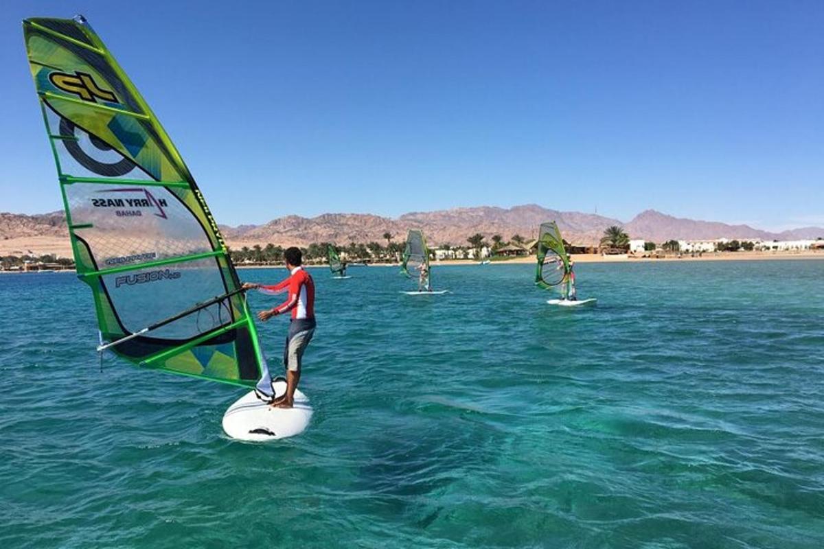 μια ομάδα ανθρώπων που κάνουν windsurfing στο νερό