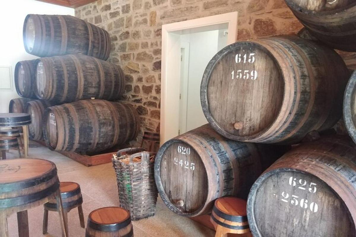 a stack of wine barrels in a room with stools
