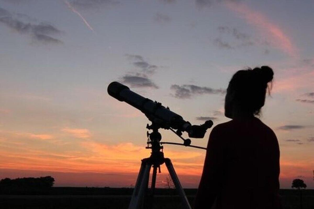una dona mirant el cel amb un telescopi