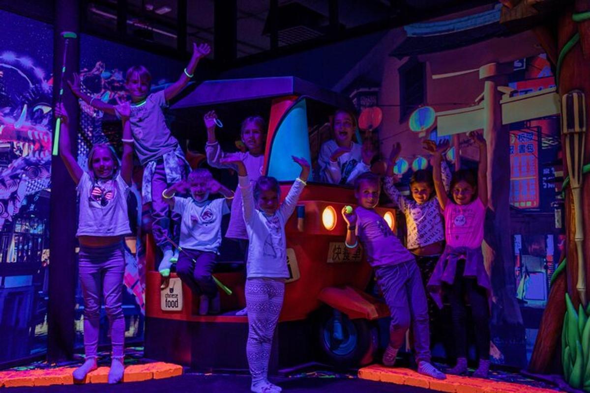 a group of children standing on a stage with their arms in the air