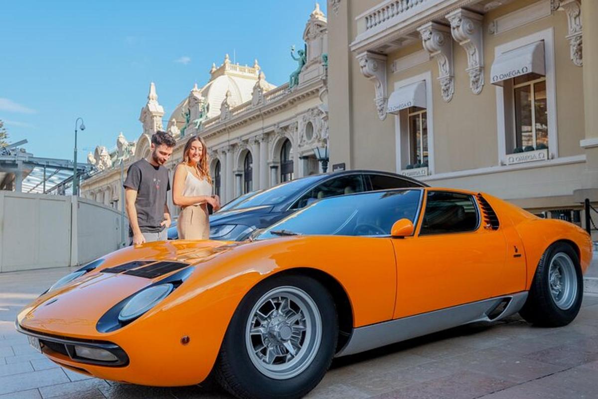 um homem e uma mulher parados ao lado de um carro laranja