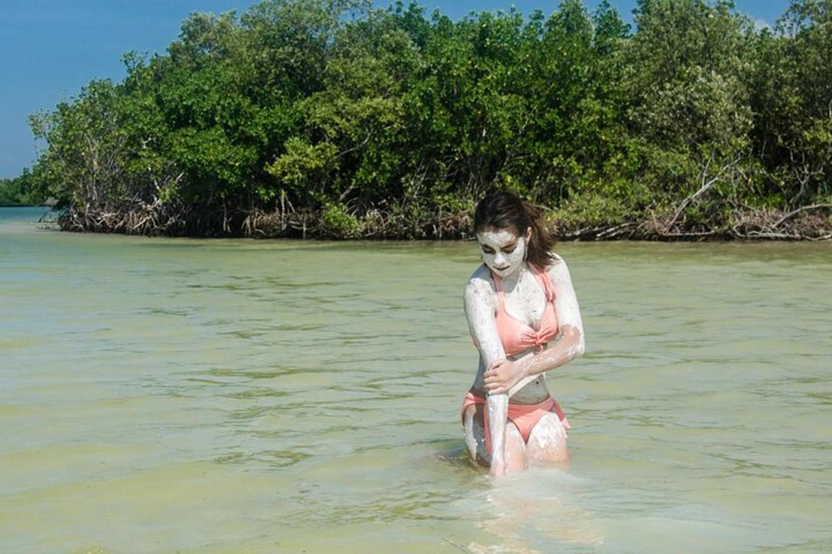 seorang gadis muda berdiri di air di pantai