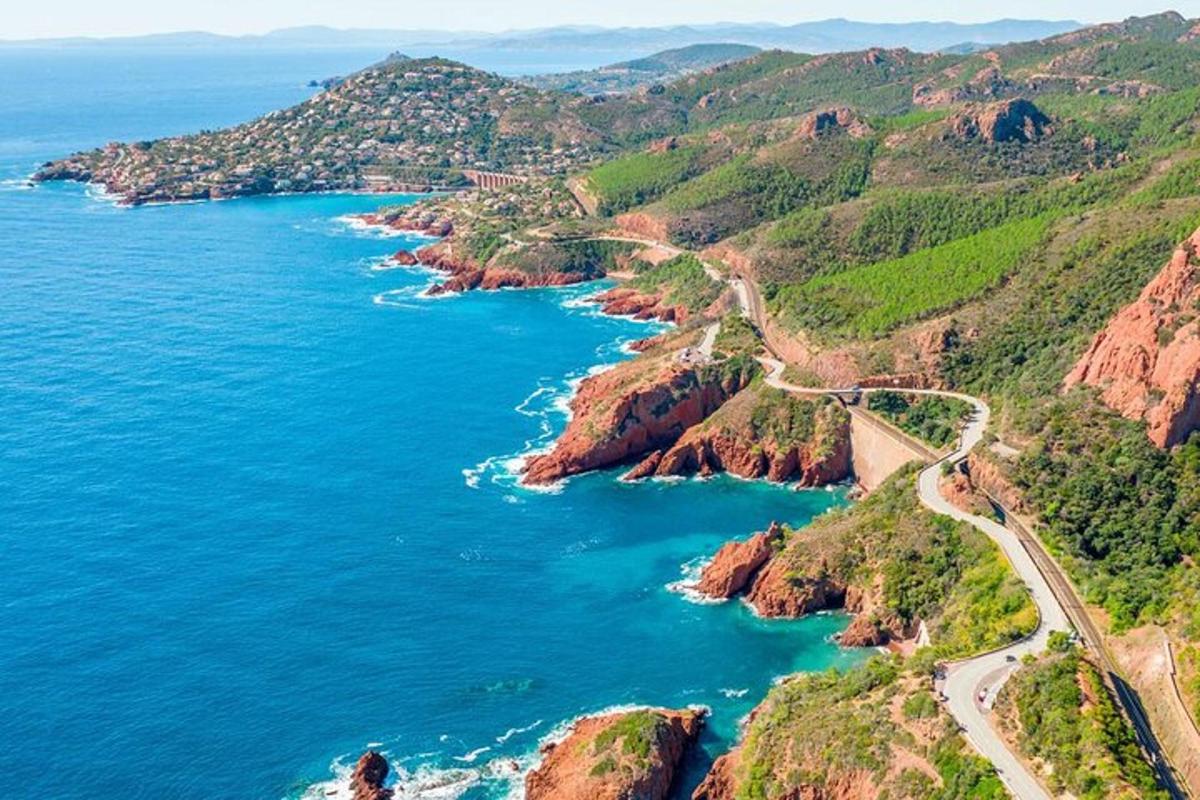 an aerial view of the ocean and a road on a mountain
