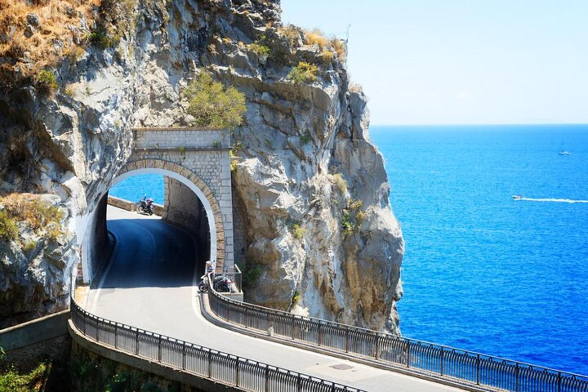 una carretera al costat d'una muntanya al costat de l'oceà