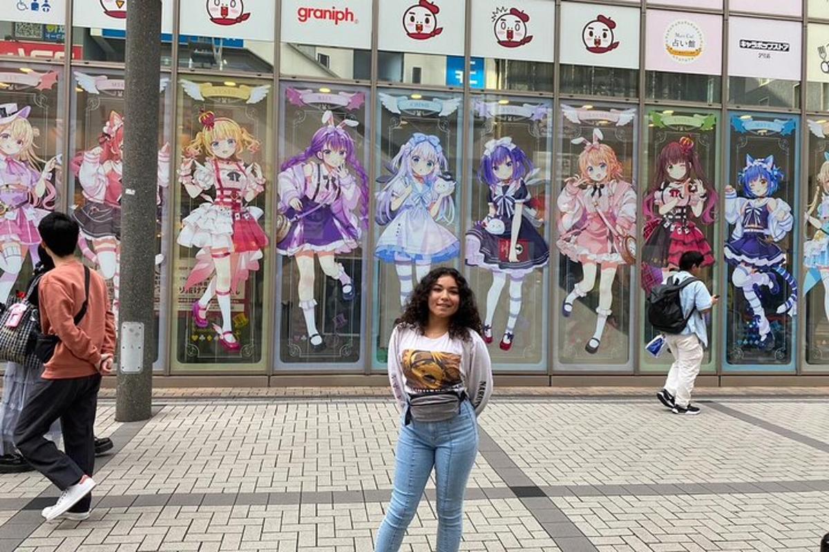 Una mujer parada frente a un edificio con paneles de anime.