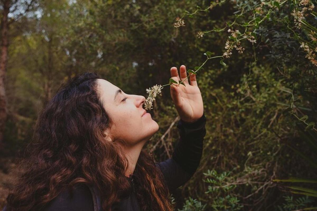 a woman is eating flowers from a tree