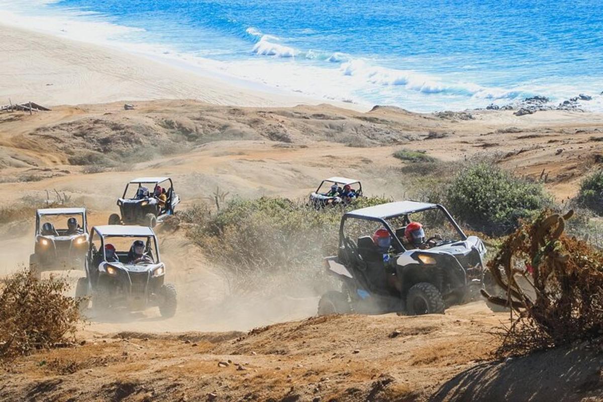 en gruppe på fire ATV-er som kjører nedover en sandstrand