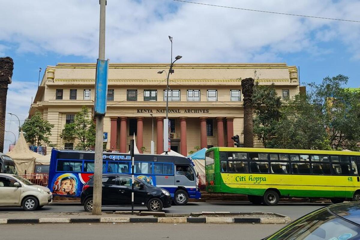 Dos autobuses están estacionados frente a un edificio.